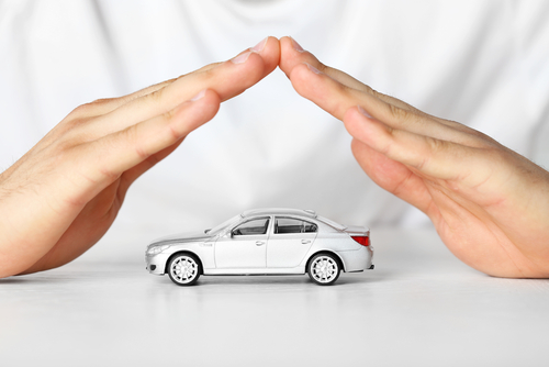Two hands pointed over a car for auto insurance